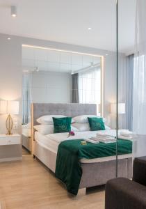 クラクフにあるGA Luxury Apartments M45のベッドルーム1室(大型ベッド1台、緑の枕付)