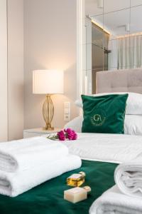 クラクフにあるGA Luxury Apartments M45のベッドルーム1室(緑と白のベッド1台、緑の枕付)