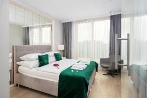 クラクフにあるGA Luxury Apartments M45のベッドルーム1室(大型ベッド1台、緑のテーブル付)