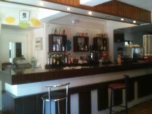 - un bar avec deux tabourets dans une pièce dans l'établissement Hôtel de la Paix, à Luzenac