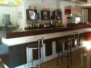un bar con cuatro taburetes en un mostrador en Hôtel de la Paix, en Luzenac