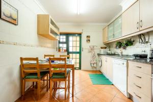 a kitchen with a table and chairs in a room at Apartamento T3 com estacionamento - Parque Natural da Ria Formosa, Olhão in Olhão