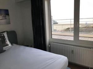 a bedroom with a bed and a large window at Penthouse Poseidon in Blankenberge