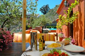 una mesa con comida y botellas de vino en el balcón en Tres Almendros by I N Z U L A E, en Vega de San Mateo