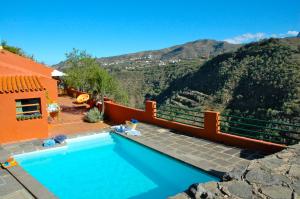 uma piscina em frente a uma casa com uma montanha em Tres Almendros by I N Z U L A E em Vega de San Mateo