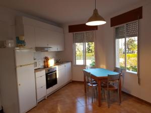 a kitchen with a table and chairs and a refrigerator at Catalejo 5 Aguilas,Murcia in Águilas