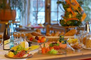 Dohlmühle Gästehaus & Weingut في فلونهايم: طاولة مع أطباق من الطعام وزجاجات من النبيذ