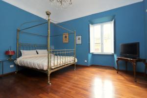 una camera da letto con pareti blu, un letto e una TV di Trevi Grand Blu Suite B&B a Roma