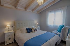 Un dormitorio con una cama grande y una lámpara de araña. en Casas Rurales Prunus Avium, en Cambrón
