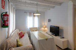 a living room with a couch and a tv at Casas Rurales Prunus Avium in Cambrón