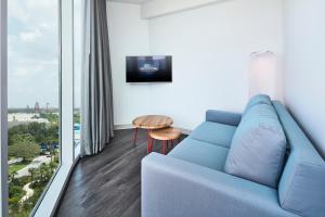 オーランドにあるUniversal's Aventura Hotelの青いソファと大きな窓のあるリビングルーム