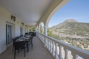 a dining room with a balcony with a table and chairs at Villa Anuska - Plusholidays in Calpe