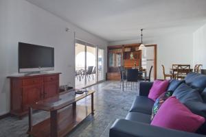 a living room with a blue couch and a tv at Villa Jazmin in Calpe
