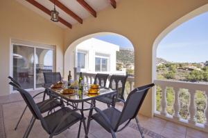 a dining room with a table and chairs on a balcony at Villa Jazmin in Calpe