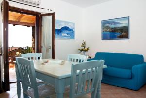 a dining room with a table and a blue couch at Residence Il Casale in Palinuro