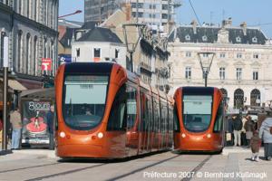two orange trains on a street in a city at Studio cozy hypercentre in Le Mans