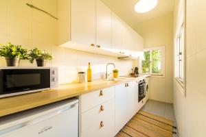 a kitchen with white cabinets and a microwave at DA'HOME - Cedofeita Art Studio in Porto