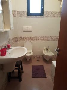 een badkamer met een wastafel, een toilet en een raam bij Casa vacanze Cilento in Torraca