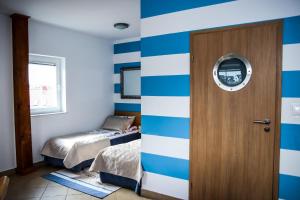 a room with blue and white striped walls and a door at Villa Pod Żaglami in Rusinowo