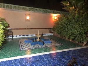 ein Brunnen mitten im Pool in der Nacht in der Unterkunft Le Sauvage Noble in Zagora