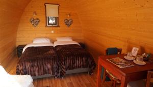 ein Schlafzimmer mit 2 Betten und einem Tisch in einem Zimmer in der Unterkunft Buitengewoon Overnachten in Terheijden