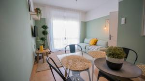 uma sala de estar com uma mesa e cadeiras e um sofá em DA'HOME - Marquês Lovely 2BD Apartment no Porto