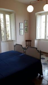 - une chambre avec un lit bleu et 2 fenêtres dans l'établissement La Dimora del tempo ritrovato, à Roccamandolfi