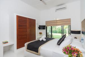 ein Schlafzimmer mit einem großen Bett und einem Fenster in der Unterkunft Garden Villa Ronnaduwa in Hikkaduwa