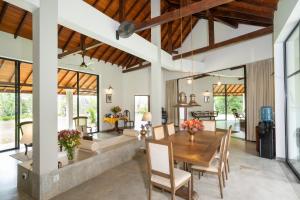 a dining room and living room with a table and chairs at Garden Villa Ronnaduwa in Hikkaduwa