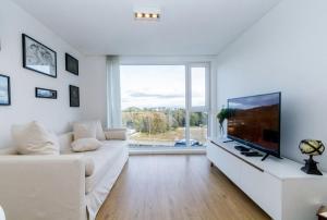 sala de estar con sofá blanco y TV de pantalla plana en Departamento Terrazas Del Beagle en Ushuaia