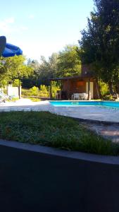 una piscina con una casa en el fondo en Cabañas los Plátanos en La Granja