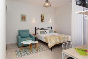 a bedroom with a bed and a chair and a table at NAIKE in Tbilisi City