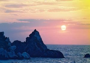 GuestHouse StrawberryFarm Shirasaki-Ⅱ / Vacation STAY19358 في Ōbiki: غروب الشمس على المحيط مع تشكيل الصخور