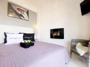 a bedroom with a white bed with two stuffed animals on it at Pure BLISS Luxury Beachfront Apartment with Panoramic Sea Views, Electric BBQ and More in Agia Triada +27 photos