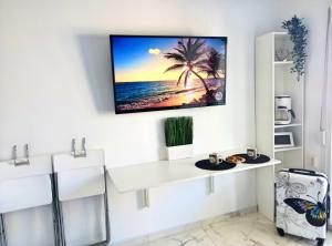 Uma TV ou centro de entretenimento em Pure BLISS Luxury Beachfront Apartment with Panoramic Sea Views, Electric BBQ, Gym Equipment and More