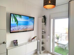 a living room with a flat screen tv on the wall at Pure BLISS Luxury Beachfront Apartment with Panoramic Sea Views, Electric BBQ and More in Agia Triada