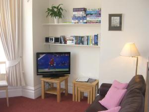 a living room with a couch and a flat screen tv at Stavordale House in Weymouth