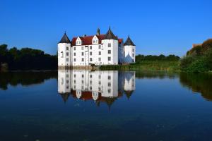 un grand château blanc au sommet d'un lac dans l'établissement Ferienhaus Strandläufer, à Langballig