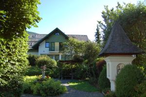 a garden with a gazebo in front of a house at Gasthaus Pension Zum lustigen Steirer in Bruck an der Mur