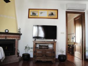 Una sala de estar con un televisor de pantalla plana en una pared. en Casa El Paseo, en Arriate
