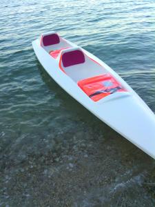 a white kayak sitting on top of the water at Camere Due Per Due in Sirolo