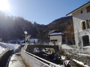 a building with a fence next to a snow covered mountain at STUDIO COSY LE ROYAL SKI 3 VALLÉES in Brides-les-Bains +13 photos