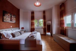 a bedroom with a large bed and a couch at Villa Aelia in Georgioupolis