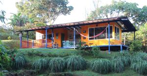a house with a wrap around porch in a garden at Casa de Campo Milagros in Filandia