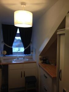 Un baño con lavabo y ventana. en Caledonia Guest House, en Plymouth