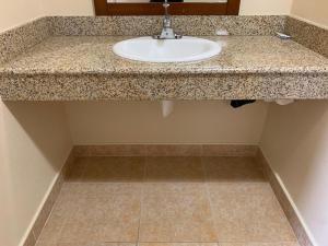 a bathroom counter with a sink and a tile floor at Fullerton Lodge in Fullerton