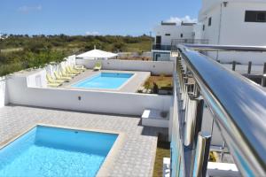 a balcony with a swimming pool on a building at Brighthelm Villas in Pereybere