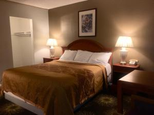 a bedroom with a bed with two lamps and a phone at Villa Park Motel in Orange