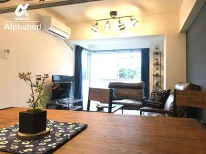 une salle à manger avec une table et un salon dans l'établissement Alphabed Takamatsukouzaiekimae 102 / Vacation STAY 20340, à Takamatsu