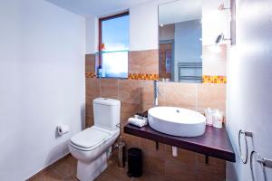 une salle de bain avec des toilettes blanches et un lavabo dans l'établissement Garden Cottage in Ambiente Guest House, à Knysna 11 autres photos